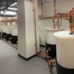 Commercial water heater bank connected with copper piping in a mechanical room
