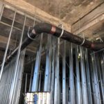 Vertical copper riser pipes with shut-off valve in a steel-framed commercial structure