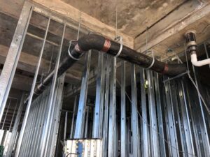 Vertical copper riser pipes with shut-off valve in a steel-framed commercial structure