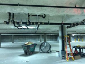 Pipe rough-in above a commercial ceiling before insulation is closed up